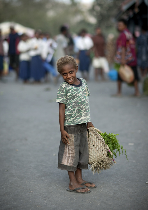 Smiling boy in Kokopo market carrying a basket, East New Britain Province, Rabaul, Papua New Guinea