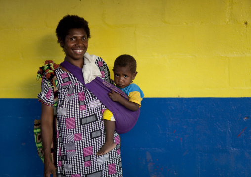 Mother and child in front of a colorful wall, East New Britain Province, Rabaul, Papua New Guinea