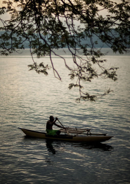 Man on a canoe on the sea at dusk, East New Britain Province, Rabaul, Papua New Guinea