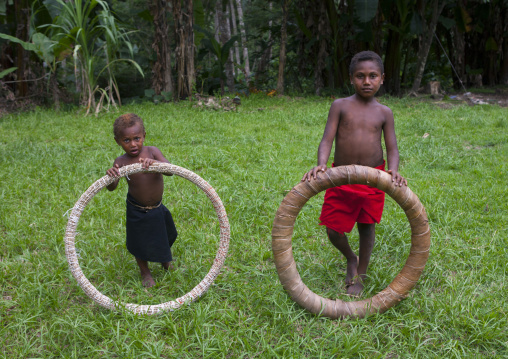 Boys holding giant shell money, East New Britain Province, Rabaul, Papua New Guinea