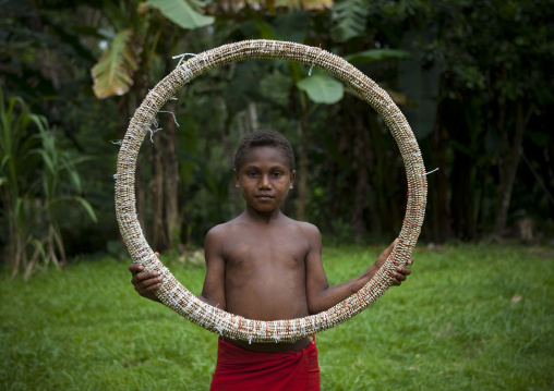 Boy holding a giant traditional shell money, East New Britain Province, Rabaul, Papua New Guinea