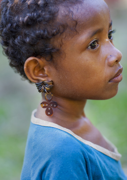 Little girl wearing earrings made with turtle shell, Milne Bay Province, Trobriand Island, Papua New Guinea