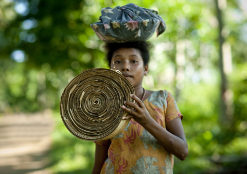 Islander girl carrying traditional money, Milne Bay Province, Trobriand Island, Papua New Guinea