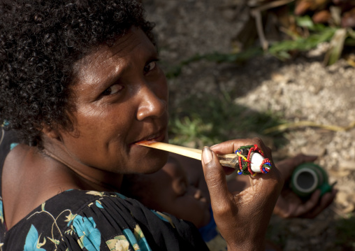 Woman chewing betel nut with a casoar bone, Milne Bay Province, Trobriand Island, Papua New Guinea