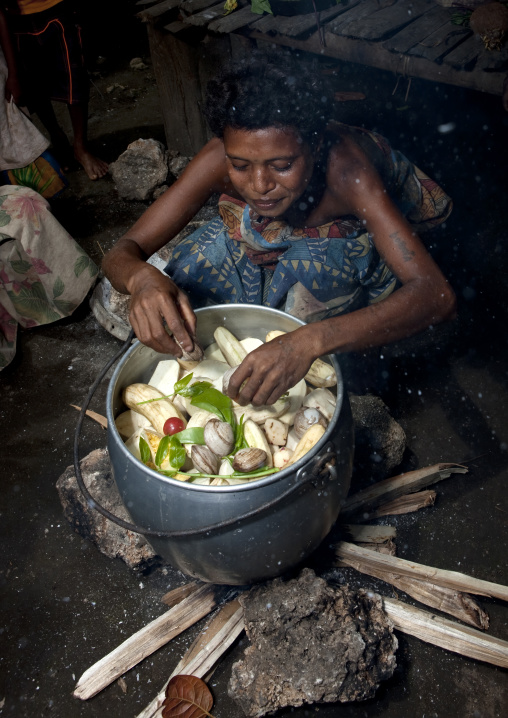 Woman making food inside her house, Milne Bay Province, Trobriand Island, Papua New Guinea