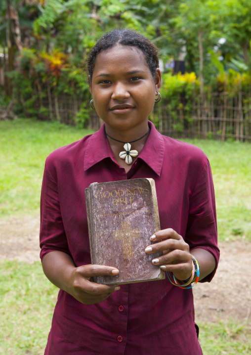 Teenage girl holding a bible, Milne Bay Province, Trobriand Island, Papua New Guinea