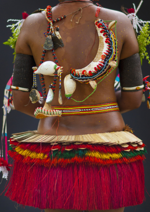 Woman wearing a traditional red skirt made with pandanus and banana leaves, Milne Bay Province, Trobriand Island, Papua New Guinea