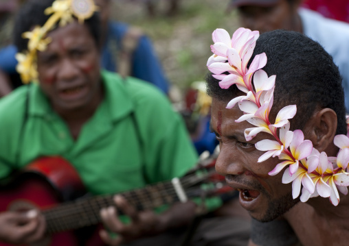 Tribal dancers during a ceremony with a man playing guitar, Milne Bay Province, Trobriand Island, Papua New Guinea