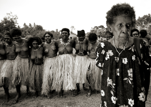 Old woman in front of dancers, Autonomous Region of Bougainville, Bougainville, Papua New Guinea