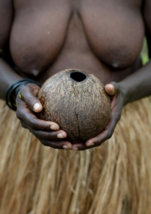 Woman in traditionnal clothes holding a coconut, Autonomous Region of Bougainville, Bougainville, Papua New Guinea