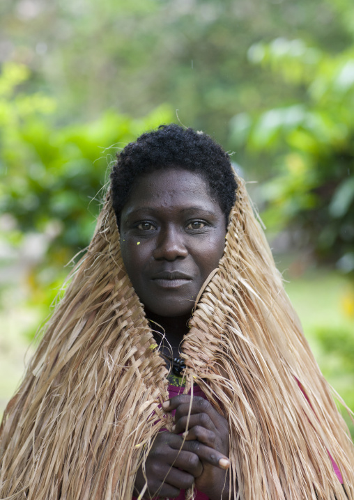 Woman protecting her head from the rain with her pandanus skirt, Autonomous Region of Bougainville, Bougainville, Papua New Guinea