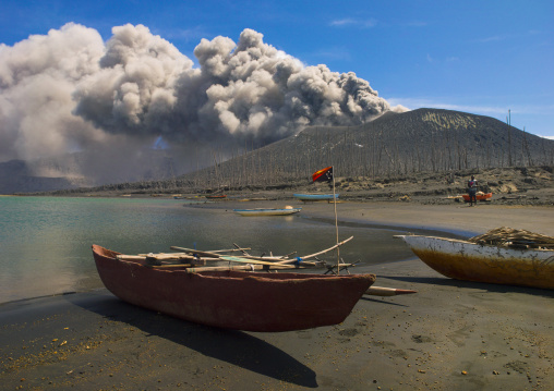 Boats in front of a volcanic eruption in Tavurvur volcano, East New Britain Province, Rabaul, Papua New Guinea