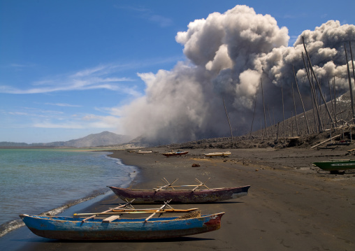Boats in front of a volcanic eruption in Tavurvur volcano, East New Britain Province, Rabaul, Papua New Guinea