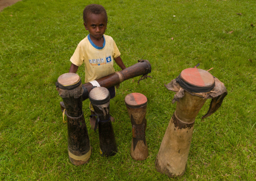 Boy with old wooden ethnic drums, New Ireland Province, Kapleman, Papua New Guinea