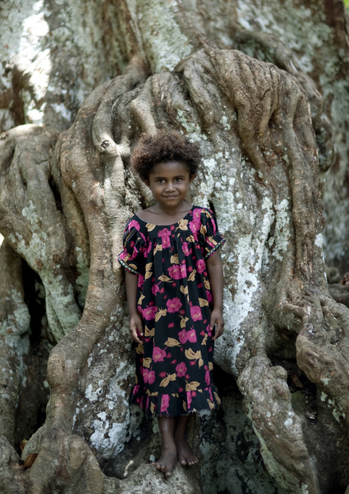 Portrait of a young girl in front of a big tree, New Ireland Province, Kapleman, Papua New Guinea