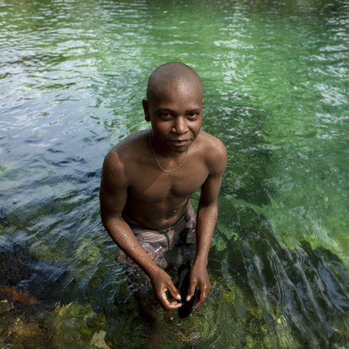Teenager boy having a bath in a river, New Ireland Province, Laraibina, Papua New Guinea