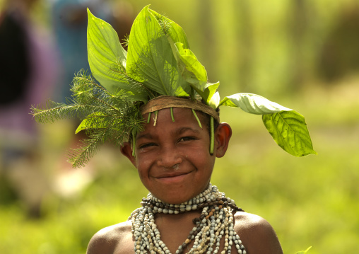 Smiling Chimbu tribe boy with a vegetal headwear during Sing-sing ceremony, Western Highlands Province, Mount Hagen, Papua New Guinea