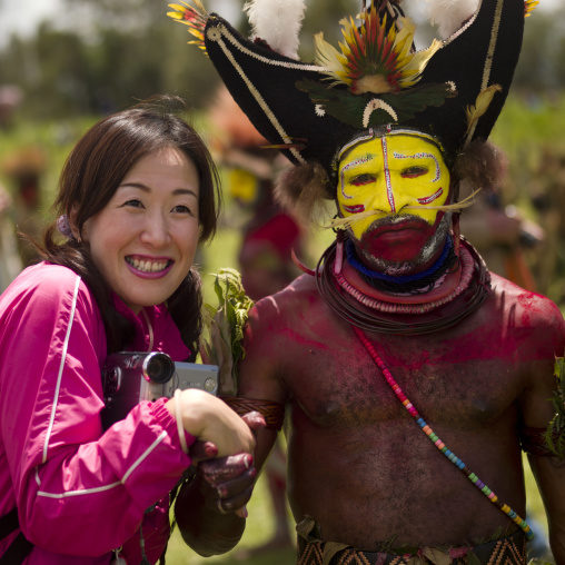 Hulis wigman with a japanese tourist during a sing-sing, Western Highlands Province, Mount Hagen, Papua New Guinea