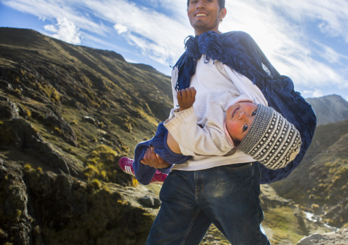 Peruvian Father Carrying His Baby On The The Way To Qoyllur Riti Festival, Ocongate Cuzco, Peru