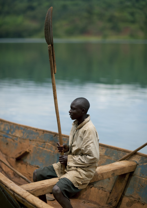 Rwandan man inside a boat holding a row, Lake Kivu, Nkombo, Rwanda