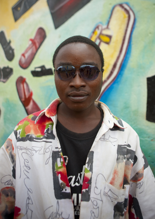 Rwandan man in front of a shoes shop mural, Kigali Province, Kigali, Rwanda
