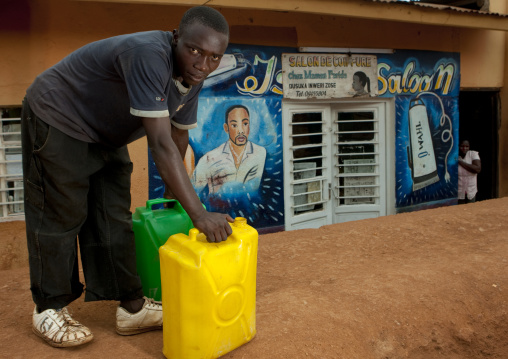 Rwandan man with jerrycans in the street, Kigali Province, Kigali, Rwanda