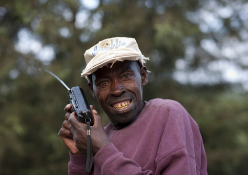 Rwandan man listening tov the radio in the countryside, Northwest Province, Rehengeri, Rwanda