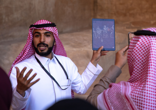 Saudi guide with tourists in Madain Saleh, Al Madinah Province, Alula, Saudi Arabia