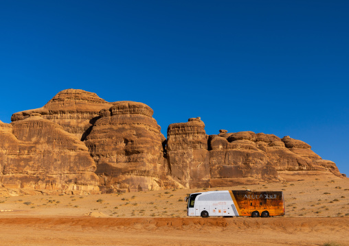 Tourist bus in the rocky landscape of Madain Saleh, Al Madinah Province, Alula, Saudi Arabia
