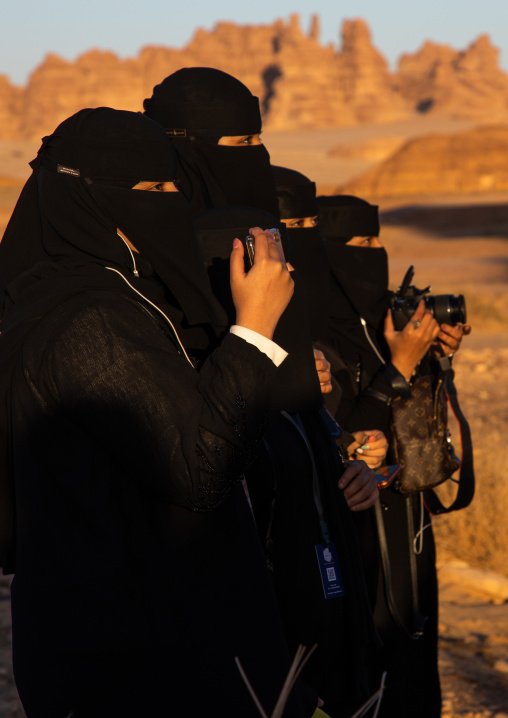 Saudi women in black niqabs taking pictures, Al Madinah Province, Alula, Saudi Arabia
