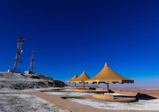Cellular transmission towers and umbrellas at the top of a hill, Al Madinah Province, Alula, Saudi Arabia