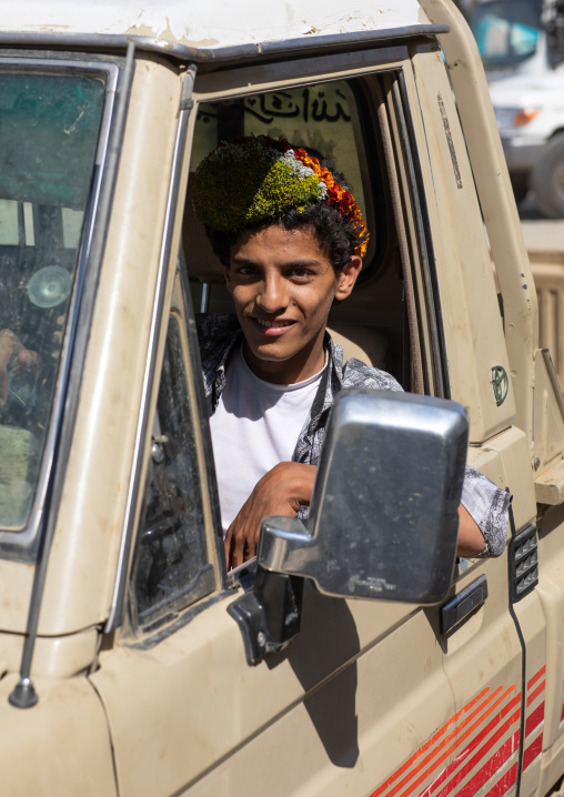 Portrait of a flower boy wearing a floral crown on the head and driving a car, Jizan province, Addayer, Saudi Arabia