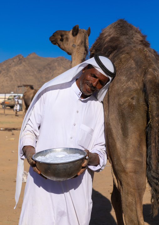Saudi man holding a bucket of fresh camel milk, Najran Province, Najran, Saudi Arabia