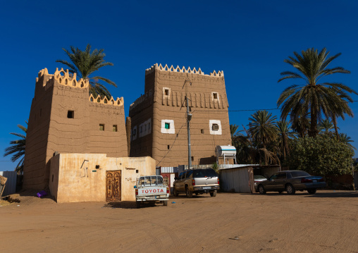 Cars parked in front of traditional old multi-storey mud house, Najran Province, Najran, Saudi Arabia