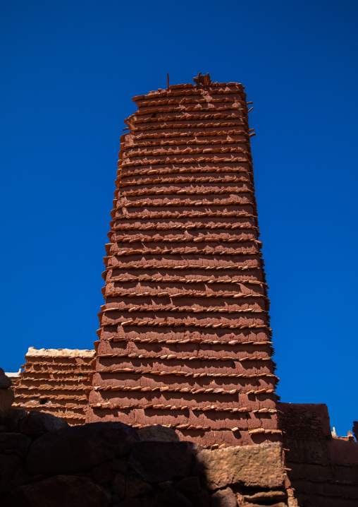 Red stone and mud watchtower with slates in a village, Asir province, Sarat Abidah, Saudi Arabia