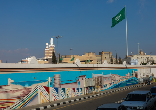 Saudi arabian flag in front of a fresco, Asir province, Abha, Saudi Arabia