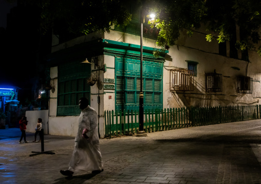 Man passing in front of an old house with mashrabiya in al-Balad quarter, Mecca province, Jeddah, Saudi Arabia