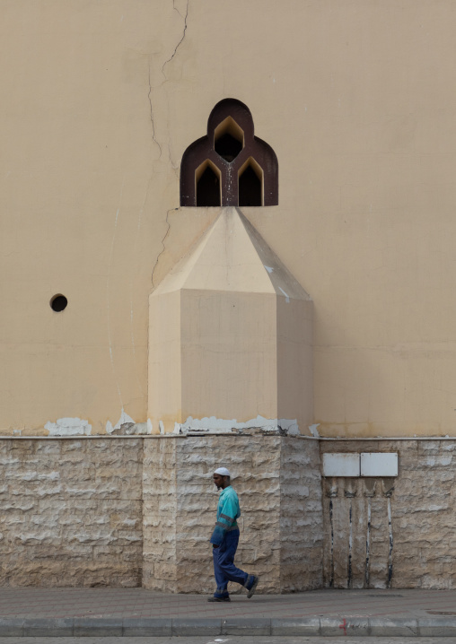 Man passing in front a the back of a mosque, Mecca province, Jeddah, Saudi Arabia