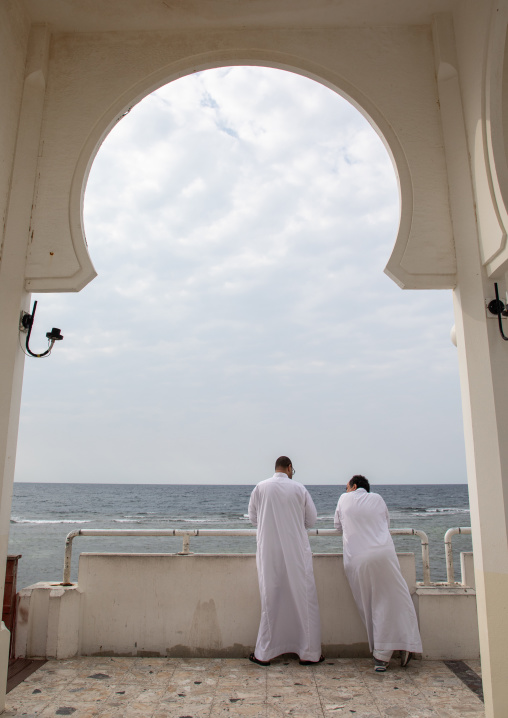 Saudi men looking at the sea inside the floating mosque or masjid bibi fatima, Mecca province, Jeddah, Saudi Arabia