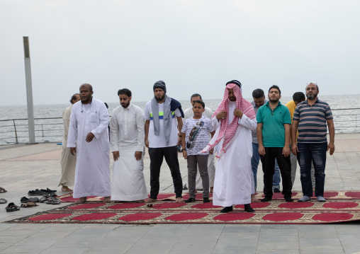 Saudi men praying on the beach, Mecca province, Jeddah, Saudi Arabia