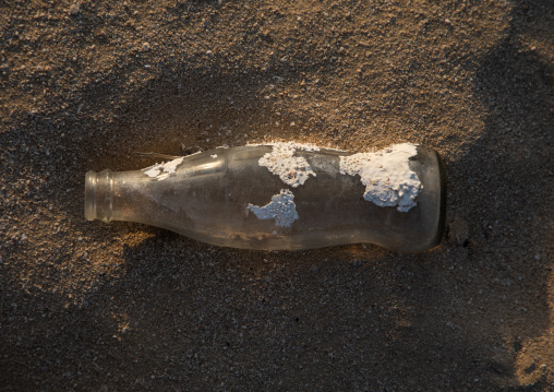 Coca Cola bottle with shell on it on a beach, Red Sea, Farasan, Saudi Arabia