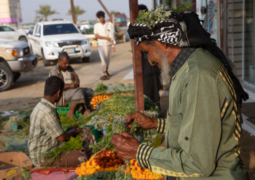 Portrait of a flower man buying a floral crown on a market, Jizan Province, Mahalah, Saudi Arabia