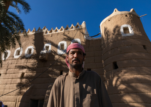 Saudi farmer standing in front of a traditional old mud house, Najran Province, Najran, Saudi Arabia