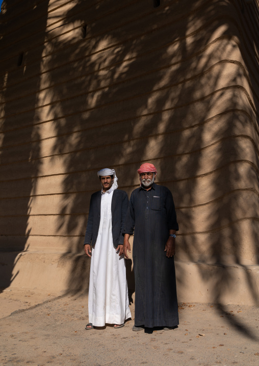 Saudi farmers standing in front of a traditional old mud house, Najran Province, Najran, Saudi Arabia