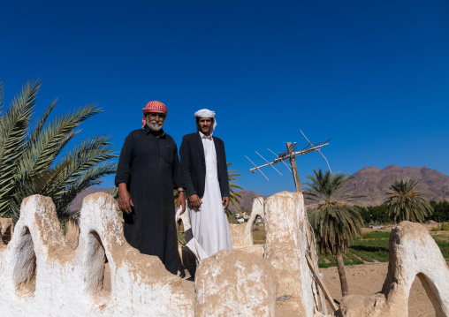 Saudi farmers standing on the terrace of a traditional old mud house, Najran Province, Najran, Saudi Arabia