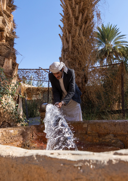 Thirsty saudi man drinking water in a farm well, Najran Province, Najran, Saudi Arabia