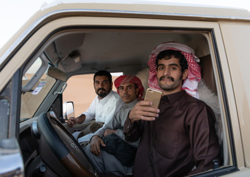 Saudi men in their toyota car taking pictures with a mobile phone, Rub al-Khali, Khubash, Saudi Arabia