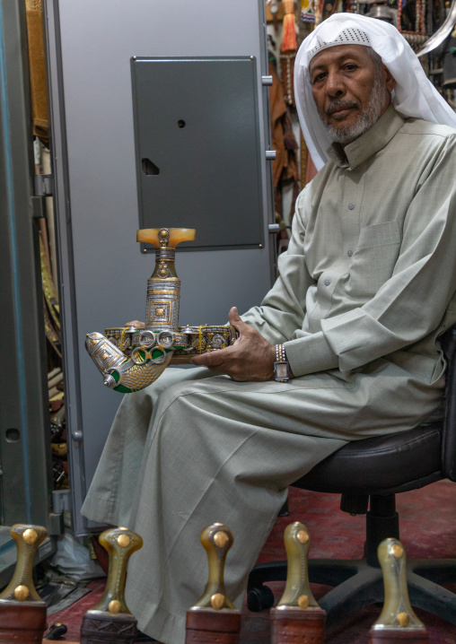 Saudi man holding a janbiya dagger kept in a safe, Najran Province, Najran, Saudi Arabia