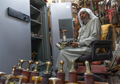Saudi man holding a janbiya dagger kept in a safe, Najran Province, Najran, Saudi Arabia
