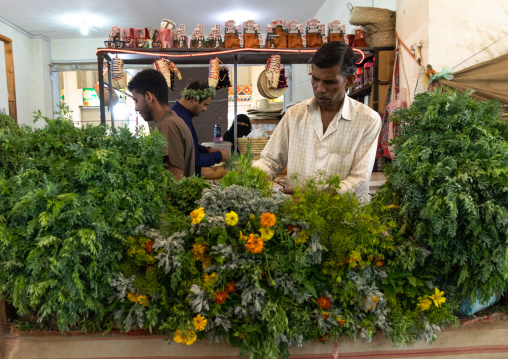 Flower vendors preparing floral garlands and crowns on a market, Asir province, Muhayil, Saudi Arabia